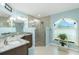 Well-lit bathroom with a dual-sink vanity, frameless shower, and window at 4 Bunker Rd, Rotonda West, FL 33947