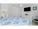 Bright bedroom features a TV, ceiling fan, and white wicker furniture for a cozy, beachy aesthetic at 4 Bunker Rd, Rotonda West, FL 33947