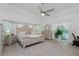 Bright bedroom with a king-size bed, ceiling fan, and sliding glass doors to the lanai at 4 Bunker Rd, Rotonda West, FL 33947