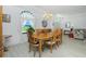 Bright dining room with a large window, chandelier, and light wood flooring offers a cozy space at 4 Bunker Rd, Rotonda West, FL 33947