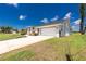 The house has an attached garage and a paved driveway, complementing the lush lawn and landscaping at 4 Bunker Rd, Rotonda West, FL 33947