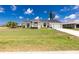 Front exterior view of a bright white house with arched windows and a green lawn at 4 Bunker Rd, Rotonda West, FL 33947