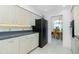 Kitchen features light cabinetry with modern black appliances, ample counter space and tile flooring at 4 Bunker Rd, Rotonda West, FL 33947