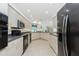 Spacious kitchen featuring light-colored cabinets, black appliances, and ample counter space for cooking at 4 Bunker Rd, Rotonda West, FL 33947