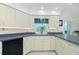 Bright kitchen featuring ample countertop space and light-colored cabinets with black appliances at 4 Bunker Rd, Rotonda West, FL 33947