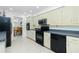 Modern kitchen with sleek black appliances, light cabinets, and view to the dining room at 4 Bunker Rd, Rotonda West, FL 33947