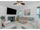 Bright living room with tile floors, a neutral sofa, two white recliners, ceiling fan, and mounted television for relaxing at 4 Bunker Rd, Rotonda West, FL 33947