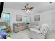 Comfortable living room includes a plush couch, white recliners, coastal decor, and a ceiling fan for Florida living at 4 Bunker Rd, Rotonda West, FL 33947