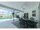 Lovely outdoor dining space with access to outdoor kitchen and screened-in pool at 4 Bunker Rd, Rotonda West, FL 33947