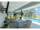 Relaxing screened patio featuring comfortable seating, a ceiling fan, views of the pool, and lush tropical landscaping at 4 Bunker Rd, Rotonda West, FL 33947