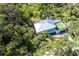 Aerial view of home with metal roof, set amongst lush tropical foliage and manicured lawns at 425 Laurel W Rd, Nokomis, FL 34275