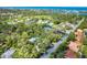 Wide aerial perspective of the property location, surrounded by a tree canopy with ocean views in the distance at 425 Laurel W Rd, Nokomis, FL 34275