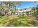 View of the back exterior of the house and the surrounding green trees at 425 Laurel W Rd, Nokomis, FL 34275