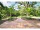 Backyard view featuring red brick patio and dense surrounding foliage at 425 Laurel W Rd, Nokomis, FL 34275