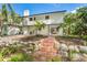 Inviting backyard with lush landscaping and brick stairs leading to a cozy patio and tropical plants at 425 Laurel W Rd, Nokomis, FL 34275