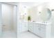 Bright bathroom featuring double sinks, white cabinets, and stylish lighting fixtures at 425 Laurel W Rd, Nokomis, FL 34275