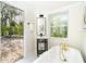 Bathroom featuring a clawfoot tub, modern vanity, and picturesque outdoor views at 425 Laurel W Rd, Nokomis, FL 34275