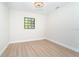Bright bedroom with hardwood flooring, modern lighting, and a window offering natural light at 425 Laurel W Rd, Nokomis, FL 34275