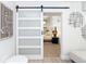 Stylish sliding barn door leads to the relaxing main bedroom with chic decor and bright natural light at 425 Laurel W Rd, Nokomis, FL 34275