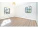 Bright bedroom featuring hardwood flooring, a modern light fixture, and natural light from two windows at 425 Laurel W Rd, Nokomis, FL 34275