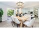 Bright dining room with white furniture, a modern chandelier, and an open view into the kitchen at 425 Laurel W Rd, Nokomis, FL 34275