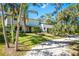 Beautifully landscaped home with a manicured lawn, palm trees, and a private driveway at 425 Laurel W Rd, Nokomis, FL 34275