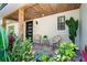 Inviting front porch with cozy seating and lush tropical plants creating a relaxing atmosphere at 425 Laurel W Rd, Nokomis, FL 34275