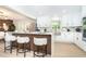 Modern kitchen with sleek white cabinets, stylish bar stool seating, and stainless steel appliances at 425 Laurel W Rd, Nokomis, FL 34275