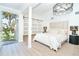 Bright and airy main bedroom with sliding barn doors, stylish lighting, and a view of the outdoors at 425 Laurel W Rd, Nokomis, FL 34275