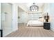 A serene main bedroom with barn doors, a modern chandelier, and a cozy neutral color palette at 425 Laurel W Rd, Nokomis, FL 34275