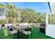 Inviting outdoor patio with full dining set, cozy lounge area and a built in grill surrounded by lush tropical landscaping at 425 Laurel W Rd, Nokomis, FL 34275