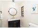 Stylish powder room with a modern black vanity, marble countertop, gold hardware, and designer mirror at 425 Laurel W Rd, Nokomis, FL 34275