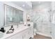 Bathroom with a walk-in shower with a glass door and marble vanity at 5 Saint John Blvd, Englewood, FL 34223