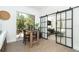 Bright dining area with a wooden table, sliding glass doors, and a view into an adjacent room with a sliding partition at 5 Saint John Blvd, Englewood, FL 34223