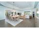 Open-concept dining and living area with a large dining table, stylish chandelier, and comfortable seating arrangements at 5 Saint John Blvd, Englewood, FL 34223