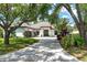 Charming single-story home with an arched entryway, tile roof, circular driveway and mature shade trees at 5 Saint John Blvd, Englewood, FL 34223