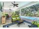 Screened lanai with comfortable seating and a ceiling fan overlooking the sparkling pool and lush backyard at 5 Saint John Blvd, Englewood, FL 34223