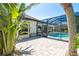 Paver patio leads to a screened lanai with a private pool at 5 Saint John Blvd, Englewood, FL 34223