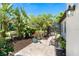 Secluded patio with lush tropical landscaping, stone pavers, and comfortable seating at 5 Saint John Blvd, Englewood, FL 34223