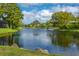 Scenic view of a tranquil pond surrounded by lush greenery and trees at 5 Saint John Blvd, Englewood, FL 34223