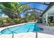 Stunning screened pool with surrounding tropical landscaping, offering a serene outdoor retreat at 5 Saint John Blvd, Englewood, FL 34223