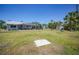 Spacious backyard featuring a screened lanai, horseshoe pit, storage shed, and lush landscaping at 5460 Norlander Dr, Port Charlotte, FL 33981