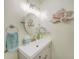 Bright bathroom featuring a round mirror, decorative seashell accents, and a modern faucet at 5460 Norlander Dr, Port Charlotte, FL 33981