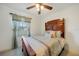 Bedroom with a decorative wooden headboard, ceiling fan and bright window with attractive curtains at 5460 Norlander Dr, Port Charlotte, FL 33981