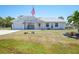 Charming single-story home featuring a well-manicured front yard and an American flag at 5460 Norlander Dr, Port Charlotte, FL 33981
