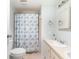 Cozy bathroom with shower, floral curtain, and a sink with cabinet space at 6168 Partridge Ave, Englewood, FL 34224