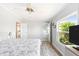 Bright bedroom, well-lit with laminate floors, a large window, and a glimpse into the en-suite bathroom at 6168 Partridge Ave, Englewood, FL 34224