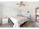 Bright bedroom with wood-look floors, ceiling fan, and light-colored walls with a striped bedspread at 6168 Partridge Ave, Englewood, FL 34224