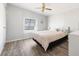 Bright bedroom with wood-look floors, ceiling fan, and light-colored walls with a striped bedspread at 6168 Partridge Ave, Englewood, FL 34224