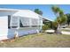Charming home exterior with well-manicured lawn, shuttered windows, and a carport for convenient parking at 6168 Partridge Ave, Englewood, FL 34224